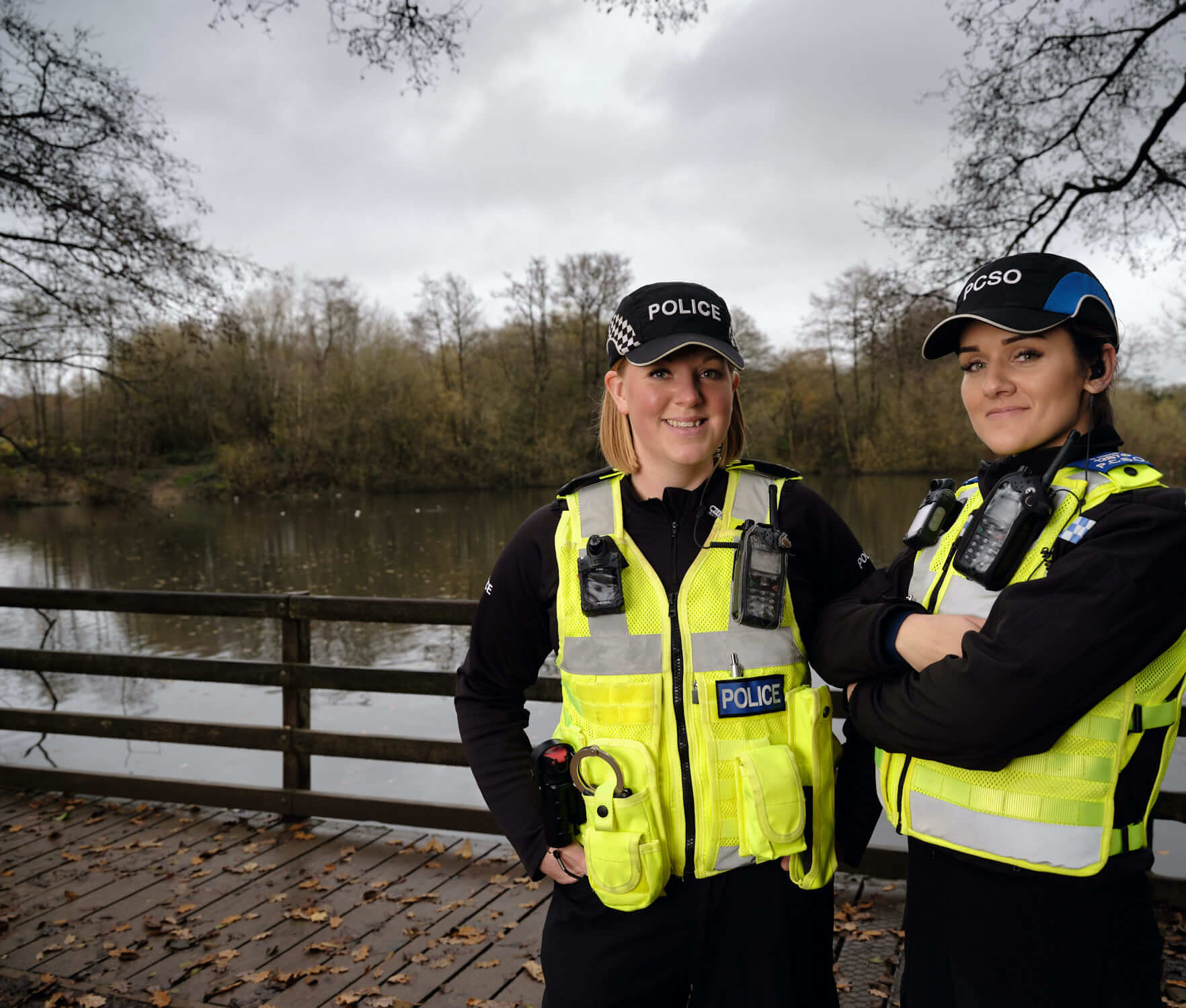 Two female police officers standing in front of a lake