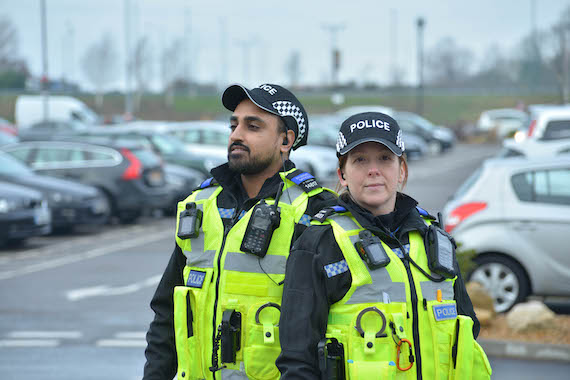 Derbyshire Constabulary Jobs | Careers Website | Asian Male and White Female Police Officers In Front of Cars Image.JPG